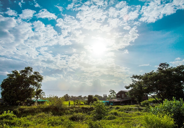 sol brillante con destello de lente. Cielo azul con nubes en la vida rural de Tailandia