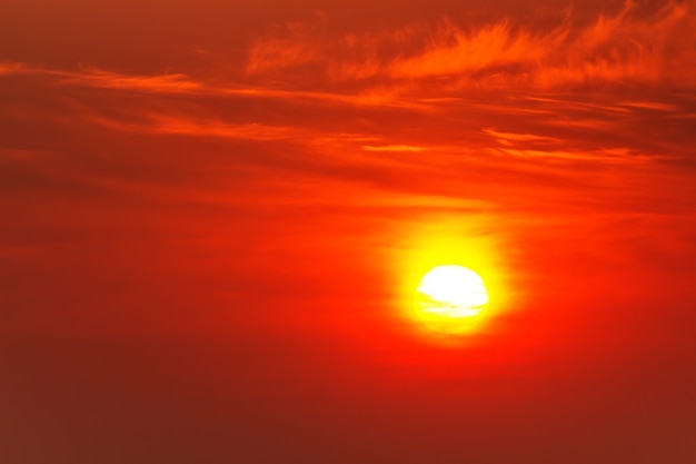 Sol carmesim brilhante em um fundo de pôr do sol ou amanhecer