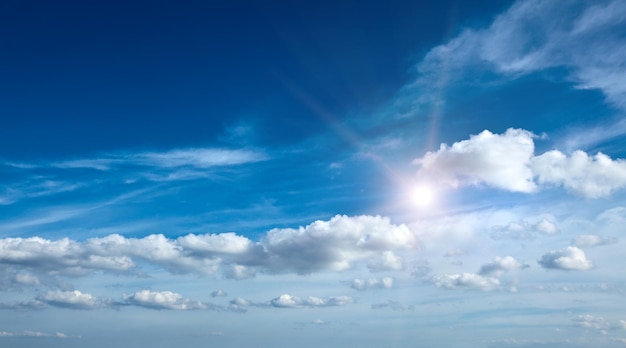 Sol com nuvens no céu azul