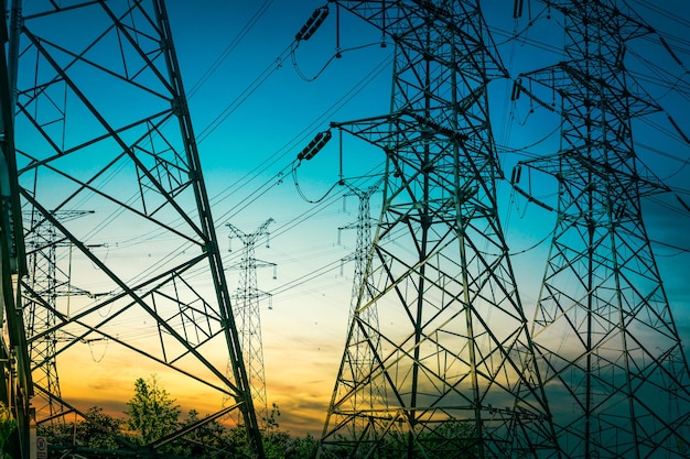 Foto sol detrás de la silueta de las torres de electricidad