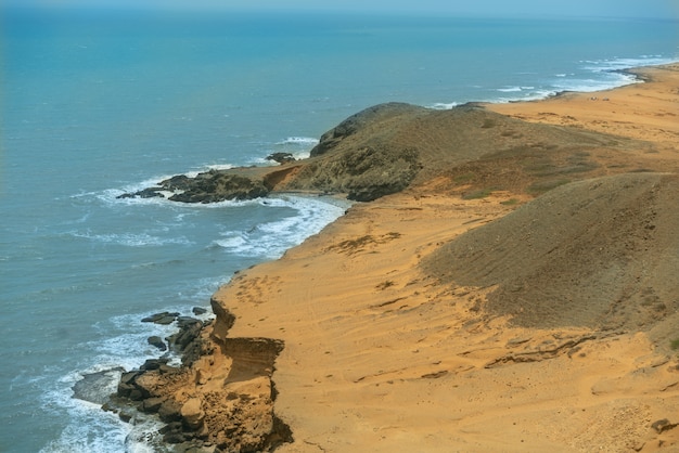 Sol do horário de verão no céu e areia da paisagem da praia