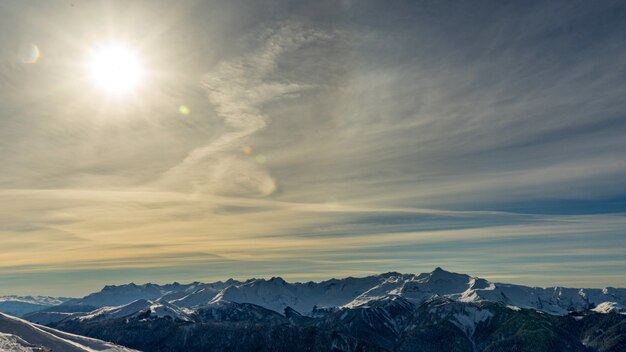 Sol forte nas montanhas do Cáucaso cobertas de neve na estação de esqui de Krasnaya Polyana, Rússia