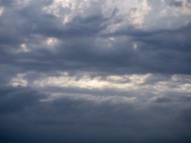 Sol forte no céu azul com nuvens escuras