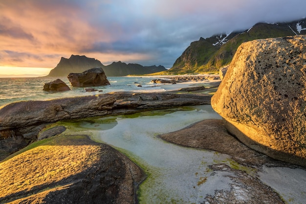 Sol de medianoche sobre la playa de Utakleiv en las islas Lofoten Noruega