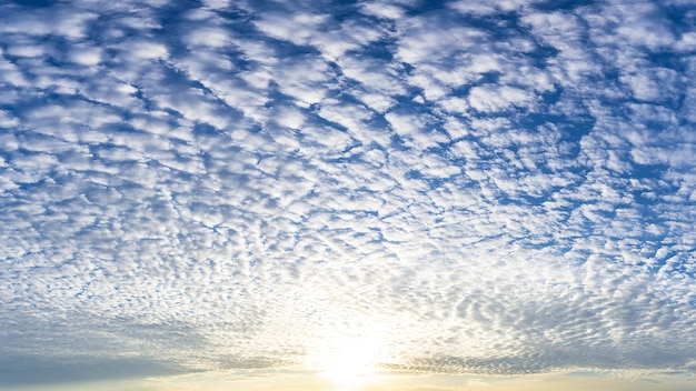 El sol y las nubes blancas mullidas llenas de cielo azul, imagen de fenómeno de la naturaleza.