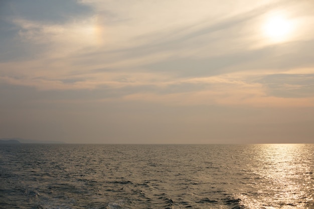 El sol se pone en el horizonte sobre el mar o el océano.