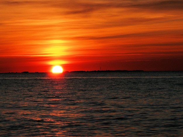 El sol se pone sobre el horizonte de la puesta de sol del mar.