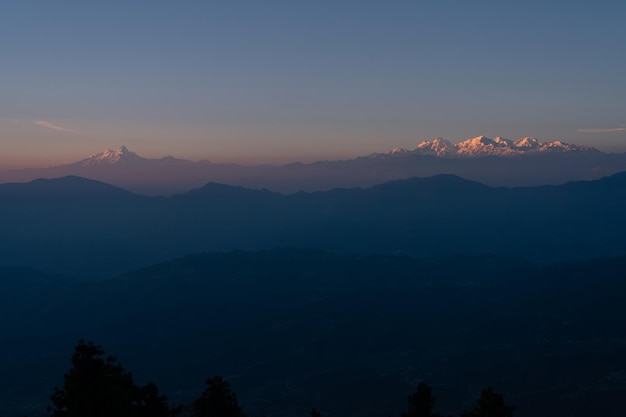 El sol se pone sobre las montañas de himachal pradesh.