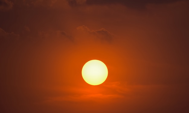 Foto el sol poniente en un fondo de cielo nublado