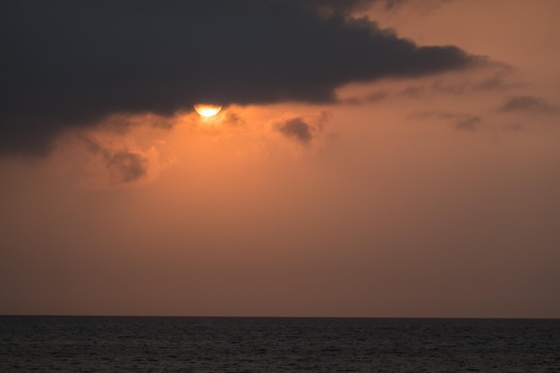 Foto sol quente atrás de uma nuvem escura de manhã em férias