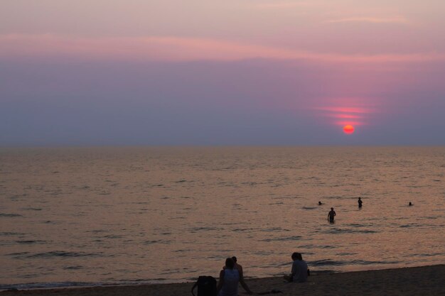 Foto sol rojo brillante en el cielo nublado por mar hermosa puesta de sol sobre el mar majestuosas nubes en el cielo