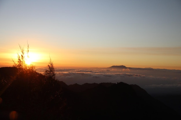 El sol sale a la izquierda del volcán Bromo en la isla de Java Indonesia