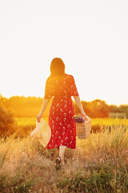 Sol y salud de la mujer vitamina d y sol de verano vista posterior mujer al atardecer en el fondo de la naturaleza joven