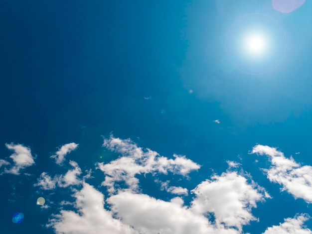 Sol sobre un fondo de cielo azul con nubes