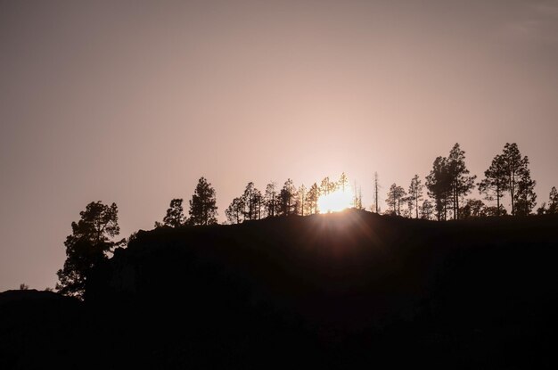 Sol sobre la silueta de una montaña en Gran Canaria España