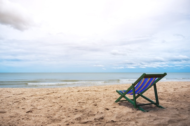 Una sola silla de playa junto al mar con fondo de cielo azul