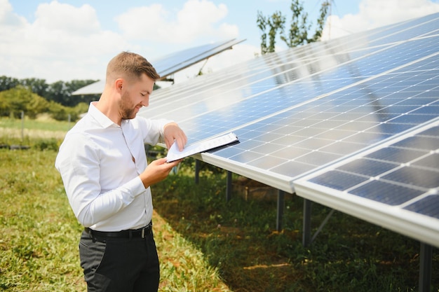 Solarenergie. Junger Geschäftsmann in der Nähe der Sonnenkollektoren zu Kraftwerken.