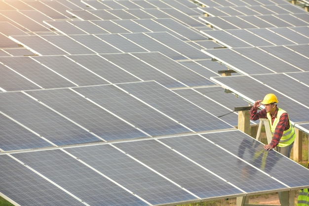 Foto solarkraftwerk, sonnenkollektoren mit techniker, zukünftige elektroproduktion, asiatische ingenieure