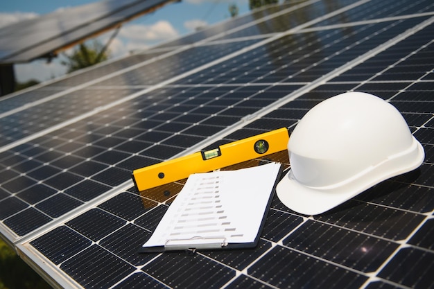 Solarzellen-vertragspartnerdokument mit orangefarbenem engineering-team-helm auf solarzellen-panels konzept für erneuerbare energien und ökologie