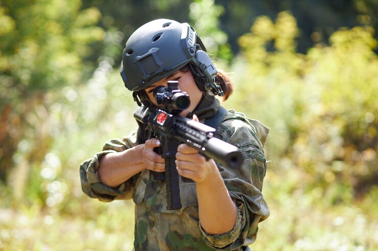 Foto soldada poderosa e esportiva pronta para a batalha usando arma de proteção militar