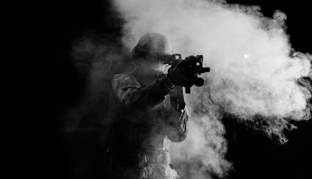 Soldado americano com munição de combate com arma nas mãos de miras a laser equipadas está em ordem de batalha. Mídia mista
