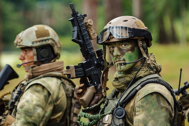 Foto el soldado se para con los brazos y mira hacia adelante.