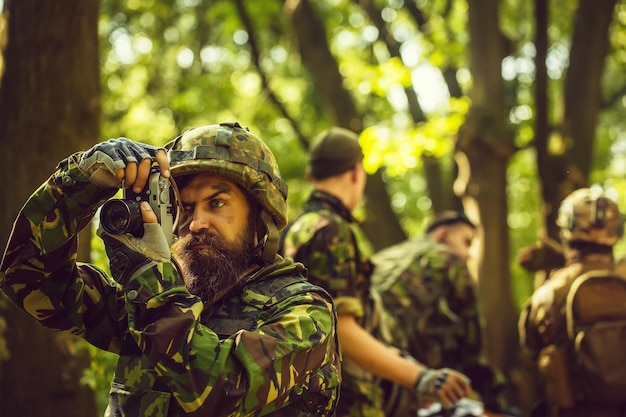 Soldado con cámara en bosque