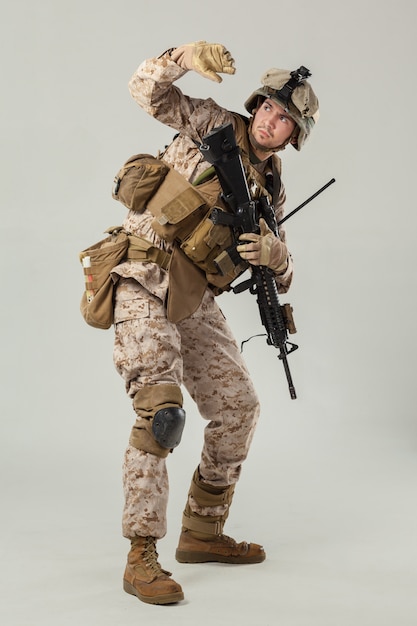 Soldado en camuflaje con rifle.