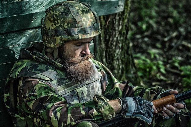 Soldado cansado Soldado del ejército con rifle de asalto y casco de combate Batalla militar en la guerra Soldado militar u oficial con armas