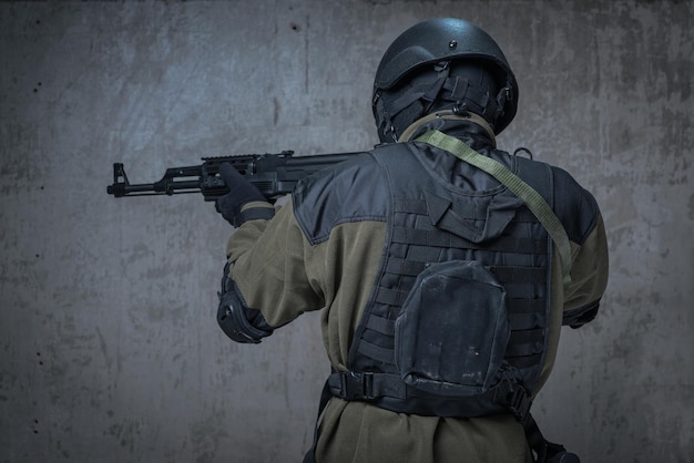 Soldado en casco con rifle automático en manos