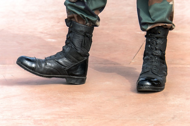 Soldado en la cima de una montaña Botas del ejército. Botas de soldado lacadas en negro. Soldados en la marcha.