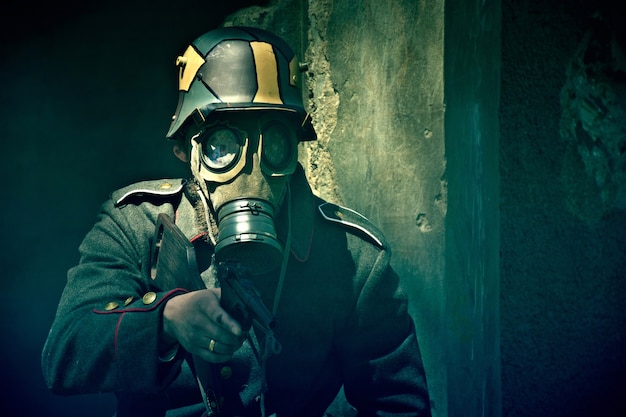 Soldado com máscara de gás aponta sua arma.