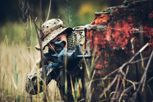 Soldado com rifle na floresta