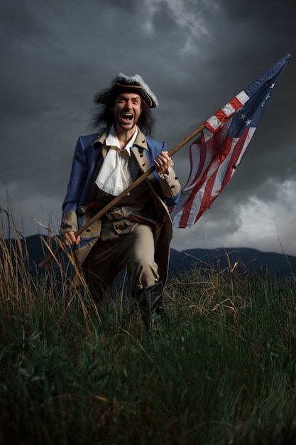 Soldado da guerra de revolução americana com bandeira das colônias sobre paisagem dramática