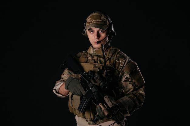 Soldado de retrato ou empreiteiro militar privado segurando a tecnologia de arma do exército de guerra de rifle sniper e conceito de pessoas imagem em um fundo preto