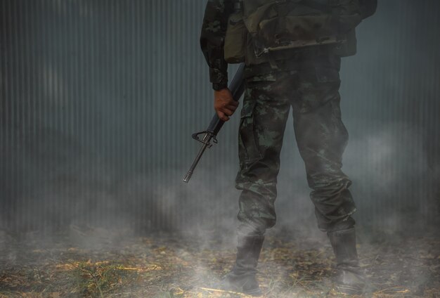 Soldado do exército em uniformes de combate com metralhadora.