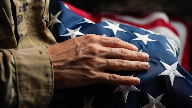 Foto soldado dos estados unidos acariciando uma bandeira dos estados unidos no dia dos veteranos