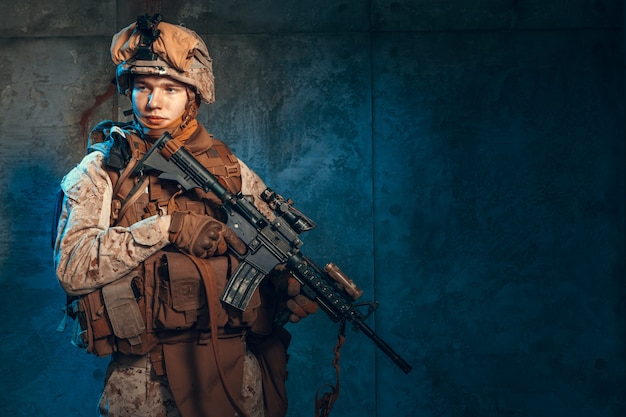 Soldado dos estados unidos das forças especiais ou contratante militar privado, segurando o rifle. imagem em um fundo escuro