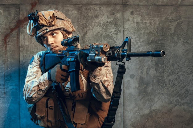 Soldado del ejército totalmente equipado con uniforme de camuflaje y casco, armado con pistola y rifle de asalto