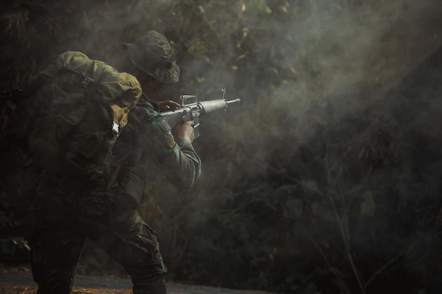 Soldado del ejército en uniforme de protección con rifle. Rifle de asalto soldado de las fuerzas especiales con silenciador. con humo