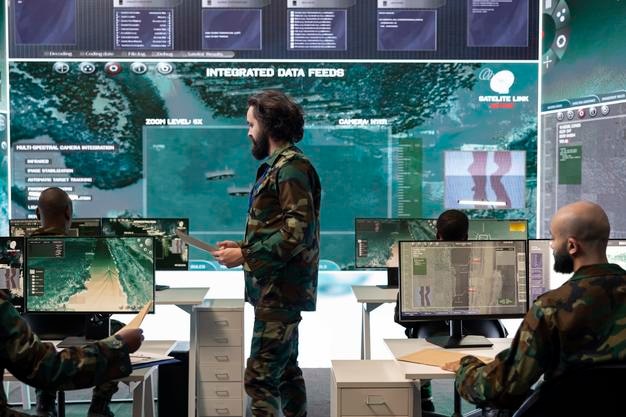 Un soldado examinando datos de reconocimiento en tiempo real en una pantalla grande.