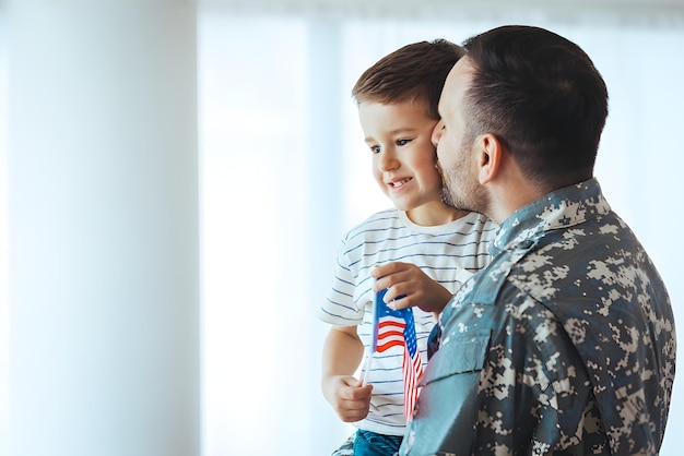 Soldado feliz brinca com seu filho Soldado se divertindo em casa com crianças