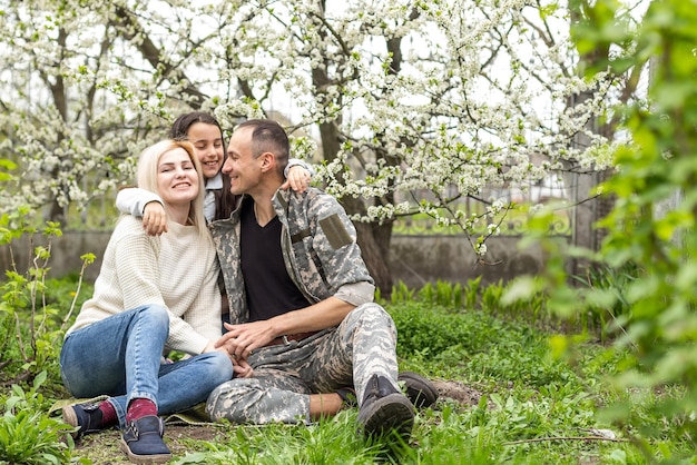 Soldado feliz con familia en el parque.