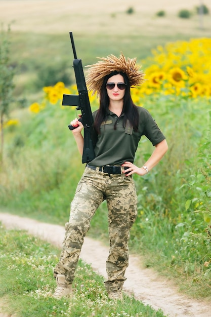 Soldado feminino em uniforme militar Uma garota em um uniforme militar com uma arma Mulher ucraniana em uma coroa de flores