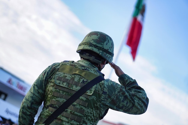 Soldado mexicano con uniforme y bandera mexicana.