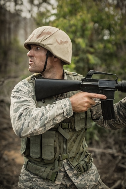 Soldado militar durante el ejercicio de entrenamiento con arma en el campo de entrenamiento