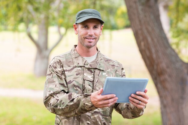 Foto soldado mirando tablet pc en el parque