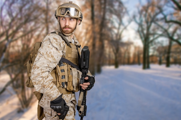 Soldado moderno con rifle en un bosque