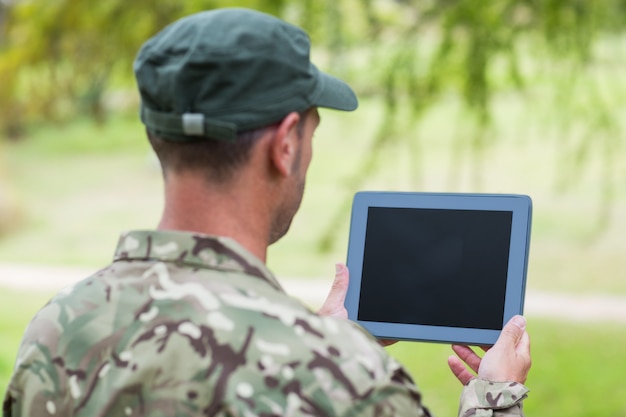 Soldado olhando para tablet pc no parque