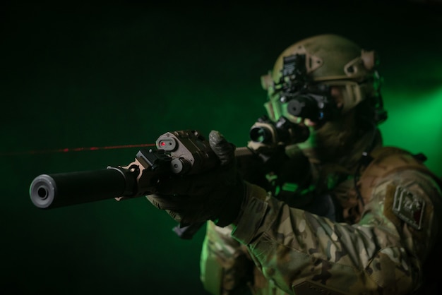 Foto el soldado en ropa militar con un dispositivo de visión nocturna y sobre un fondo oscuro